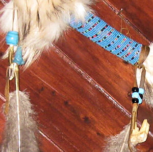 detail of beadwork and buffalo tooth and coyote tooth on spirit chaser stick