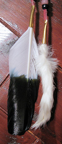 detail of eagle feathers and faux mink tails on peace pipe